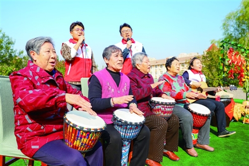 重阳节临近,10月28日,在青岛市李沧区社会福利院开展的“爱满重阳”主题活动中,志愿者和老人们一起表演节目。新华社发